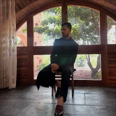 A moment of quiet reflection during a shoot for men's ethnic wear. The silhouette of the bandhgala against the arched window creates a powerful, regal image.