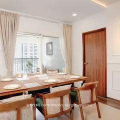 A bright and airy dining space designed for family meals. The use of natural wood tones and simple, elegant chairs creates a welcoming atmosphere that connects seamlessly to the outdoor balcony.