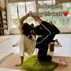 A student gracefully holds a challenging backbend, demonstrating the strength and flexibility cultivated through consistent practice. The beautiful energy of the class is palpable.