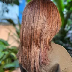The back view showcases the seamless blend of this mahogany glaze. The layered cut adds movement, allowing the different tones in the balayage to stand out.