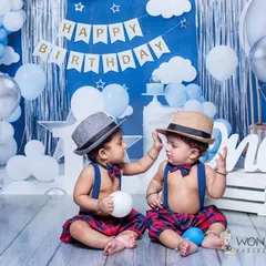 A first birthday for twins is a momentous occasion. I designed this blue and silver themed shoot with matching outfits and hats to celebrate their first year together in style.
