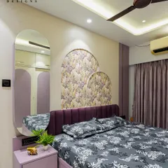 A bedroom design featuring a rich purple upholstered headboard and matching lavender wardrobes. The arched wallpaper panels and mirror create a cohesive and elegant look.
