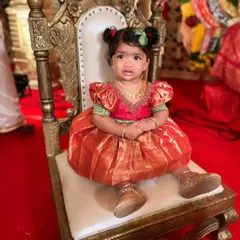 Seated like royalty on her little throne, this cutie is wearing her custom silk frock for a special ceremony.