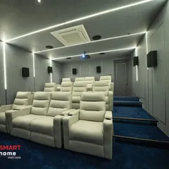 The combination of cool gray acoustic panels, blue carpeting, and bright white LED strip lighting gives this Madurai home theater a distinctly modern and futuristic feel. The design is both visually striking and acoustically functional.