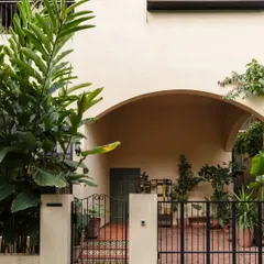 The entrance to one of our most instagrammable homes. The arched entryway and lush greenery create an inviting transition from the outside world into a serene, light-filled sanctuary.