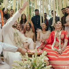 The couple shares a laugh with their friends and family during the wedding rituals. These candid group moments are precious memories.