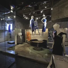 The interior of the Gaurav Gupta couture store in New Delhi was conceived as a sculpted cavern. Raw concrete walls and strategically placed mirrors create a dramatic, gallery-like environment where the fashion pieces are displayed as artifacts.