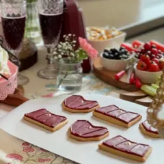 Custom bag-shaped cookies we created for a brand's Mother's Day campaign. These shortbread cookies are topped with maroon icing and a tiny gold detail to match the client's product.