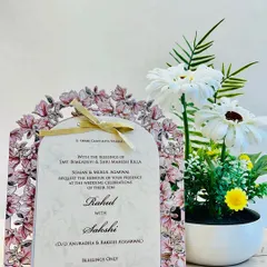 This elegant invitation features a stunning laser-cut floral arch. The main insert is tied with a delicate ribbon, creating a beautiful presentation.