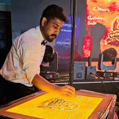 A focused moment during the live performance for Crompton. Every grain of sand is carefully placed to build the narrative and create a visually stunning experience for the audience.