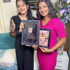 Celebrating another student's graduation. She's proudly showing off her certificate and the frame full of designs she mastered in the course.