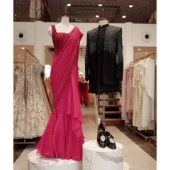 For cocktail evenings, I suggest refined statements. This display pairs a sharply tailored, embellished black bandhgala with a striking draped saree, complete with elegant footwear to finish the look.