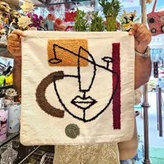 This abstract face cushion cover is a piece of art for your sofa. The tufted embroidery adds a unique texture and a modern, artistic flair to your living room.