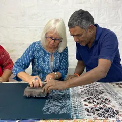 Our workshops are built on personal guidance and shared knowledge. Here, one of our master artisans guides a participant, ensuring she finds her rhythm. It's a collaborative process, where decades of experience meet fresh curiosity.