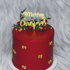 Christmas continues with this elegant red cake. It's decorated with little gold bows and a "Merry Christmas" topper, making it a simple yet festive addition to your holiday celebration.