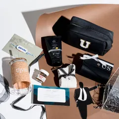 A deconstructed view of the Classic Black Box, showing the personalized travel pouches, a cork-sleeve tumbler, and other curated items for a modern Rakhi gift.