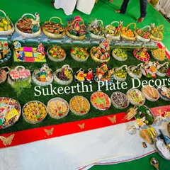 Another angle of the grand 45-plate puberty ceremony setup. You can see the variety of items, from sweets and savories to fruits and decorated baskets, all meticulously arranged.