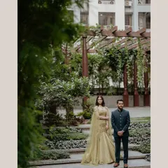 A professional shot of the couple. The bride's makeup looks stunning even from a distance, complementing the elegant outdoor setting.