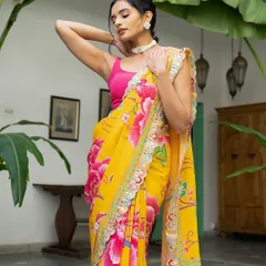 This portrait showcases the stunning details of the yellow floral saree and the modern pink blouse. The model's confident pose and the beautiful outdoor light make this a perfect shot for a contemporary ethnic brand.