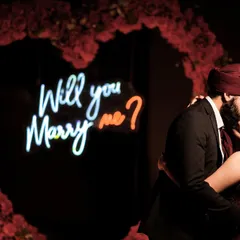 A close-up of the kiss that sealed the deal, with the neon sign in the background.