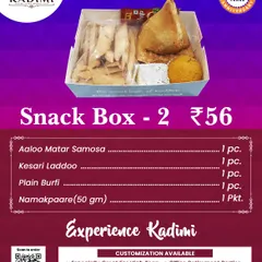 Our Snack Box 2 includes a mix of sweet and savory items. It contains an Aloo Matar Samosa, Kesari Laddoo, Plain Burfi, and Namakpaare, offering a balanced snack experience.