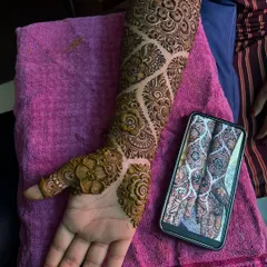 The palm-side view of this intricate engagement mehendi. The design features a beautiful flower on the back of the hand.