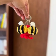 A sweet little accessory. This keychain features two kissing bees, a perfect small gift to show someone you care.