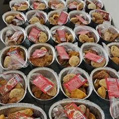 Assorted snack boxes prepared for a festival, containing a variety of fried and steamed items suitable for the occasion.