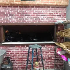 A red brick wallpaper used around a service window in a commercial kitchen, providing a classic pizzeria or cafe look.