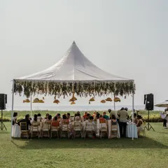 A beautiful beachside wedding lunch setup under a large white tent at Niraamaya Wellness Retreats, offering guests stunning ocean views.