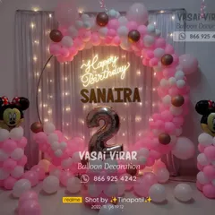 A classic Minnie Mouse theme for a second birthday. We used a pink and white color scheme with a circular backdrop, a neon sign, and adorable Minnie Mouse balloon pillars to create a sweet and charming party setting.