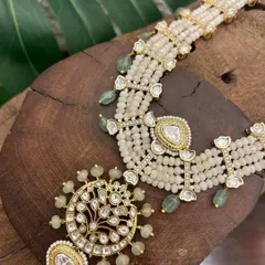 This stunning kundan and pearl set, with its intricate chandbali-style earrings and matching choker, is crafted to make you feel unforgettable.