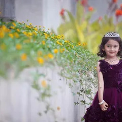 A lovely portrait of the birthday girl in a garden setting. The natural flowers and greenery create a beautiful, soft background.