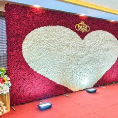 A slightly different angle of the heart-shaped floral wall, showing how the uplighting enhances its texture and color. This romantic backdrop is one of my signature offerings for weddings and engagements.