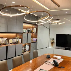 The lighting and storage in this conference room are completely custom. The interlocking ring lights provide excellent illumination, while the built-in shelving offers a clean, organized space to display company awards and achievements.