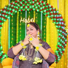 This playful shot from a Haldi ceremony shows the floral haath phool and earrings up close. The yellow flowers are perfect for the occasion.