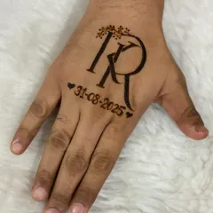 A clear, still shot of the groom's initial monogram. The letters are intertwined and adorned with a delicate leafy vine, with the wedding date marked by small hearts.