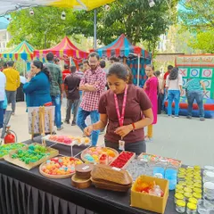 A participant at our live booth at Eco Space selects from a wide array of colorful wax embeds to decorate her candle.