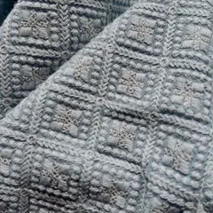 A close-up view of this beautiful blue-grey georgette fabric reveals the incredible texture of the Lucknowi embroidery. The dense, geometric threadwork creates a rich surface perfect for a statement jacket or kurta.