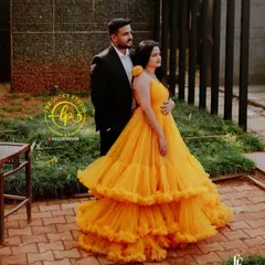 This vibrant yellow tiered gown paired with a classic black suit is a fantastic choice for a romantic and modern pre-wedding photoshoot.