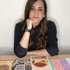 A shot of me with a collection of my recent artworks. Each piece, whether it's a coffee-stained mandala or a colorful food illustration, holds a special place in my portfolio.