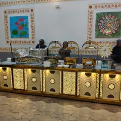Our team managing a large, illuminated live cooking station. This setup is perfect for big events, allowing multiple chefs to serve a variety of dishes simultaneously.