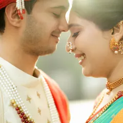 An intimate close-up from a traditional photoshoot. The soft light and genuine smiles highlight the beauty of the bride's nath and the couple's connection.