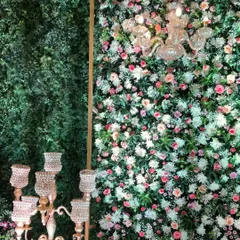 Another look at a dense floral wall, where a mix of pink, white, and cream roses are combined with baby's breath for a romantic, garden-like effect.