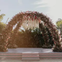 This is the mandap of my dreams. Inspired by the timeless elegance of Sabyasachi, we created this breathtaking arch with a dense canopy of red and maroon florals, pampas grass, and a stunning chandelier of white tuberoses. It was regal, rustic, and everything the couple envisioned for their sacred vows.