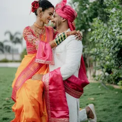 A classic romantic pose with a traditional touch. The groom gets down on one knee, not for a proposal, but in a gesture of love on their wedding day, showcasing their beautiful connection.
