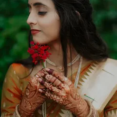 A beautiful portrait of the bride-to-be, Janhavi, in her traditional saree. The intricate henna and the delicate flower highlight her elegance and grace.