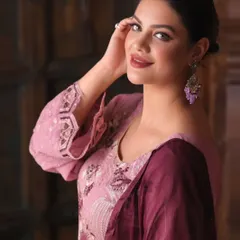 A close-up portrait from an apparel shoot, focusing on the model's expression and the details of the earrings and neckline embroidery. This type of shot adds a personal touch to a product listing.