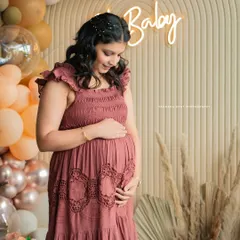 An expectant mother gently holds her baby bump during her baby shower celebration. This portrait, set against a stylish 'Oh Baby' backdrop, highlights the beautiful anticipation and glow of motherhood.