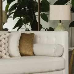 A close-up on the sofa styling, where a mix of velvet, linen, and embroidered cushions are arranged to create a look that feels collected and personal.